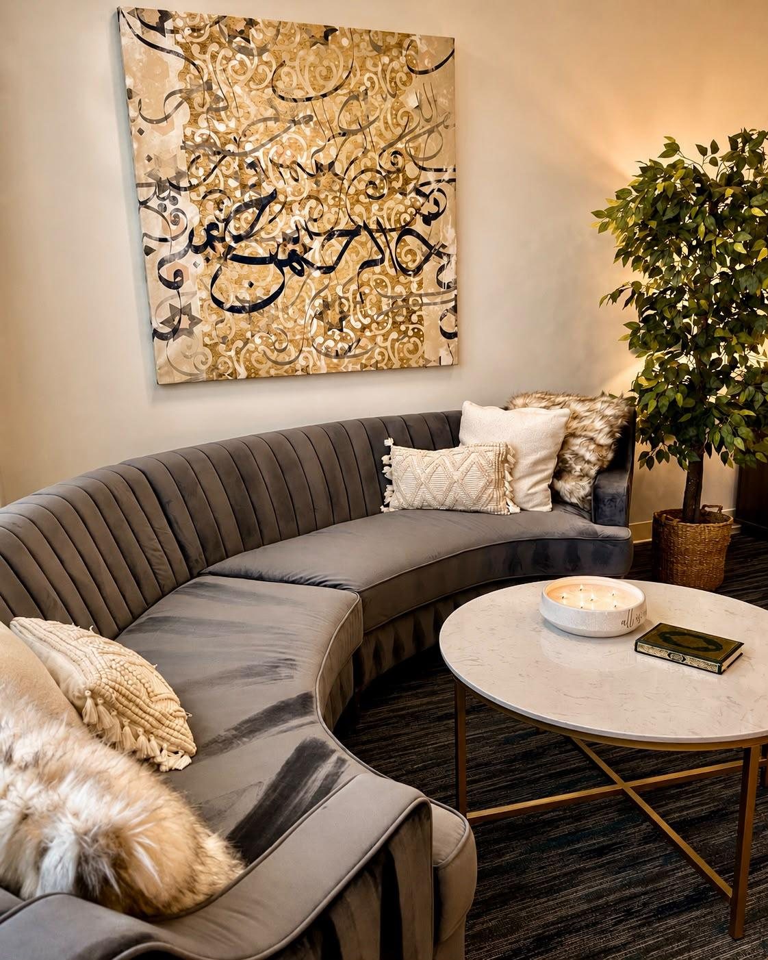 The Rahma Counseling waiting room, with a curved sofa beneath a gold Arabic calligraphy canvas